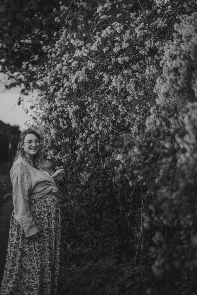 Margate Pregnancy Shoot in the Woods with Winter foliage and pregnant woman wearing vintage glasses and a boho dress