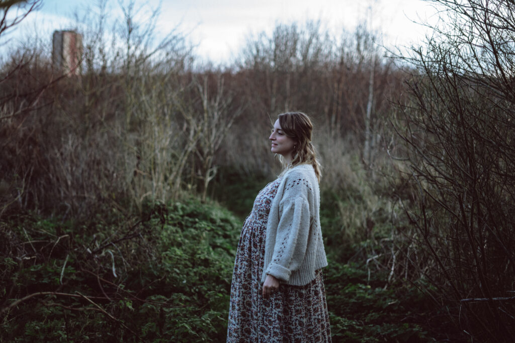 Margate Pregnancy Shoot with pregnant woman in Dane Valley Woods with a boho dress and cardigan with trees and foliage in the background