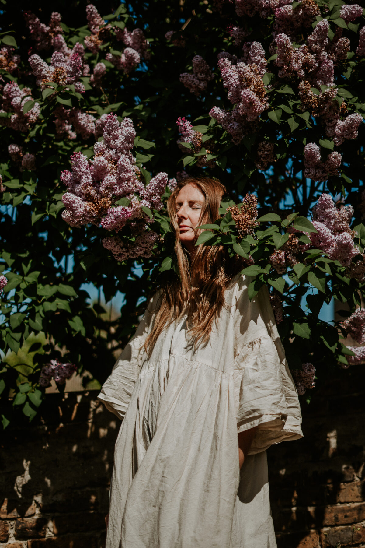 Naomi in deep reflection among leaves, illustrating emotional and nervous system repair for pelvic health from the holistic pelvic floor healing course.