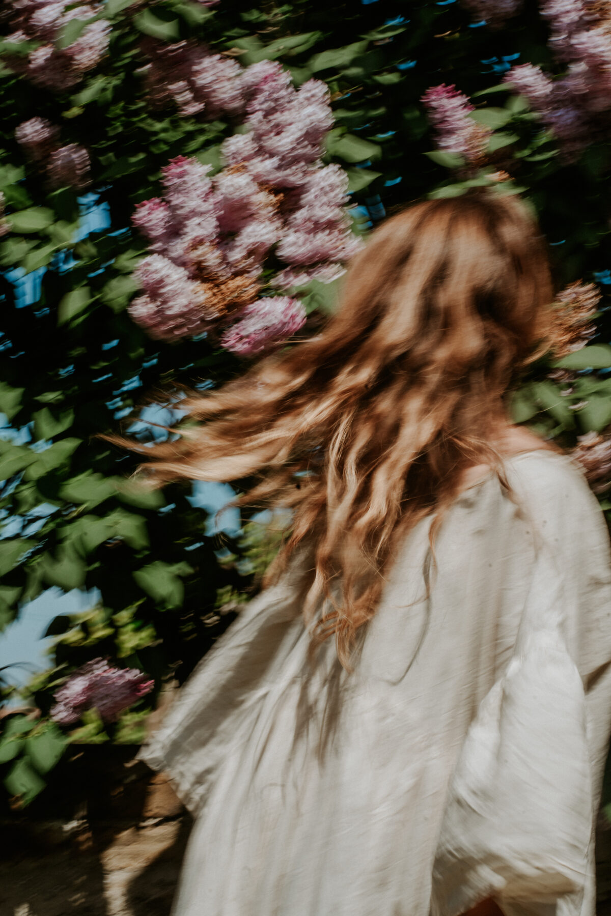 Naomi seated in nature embodying reflective practice and integration in healing.
